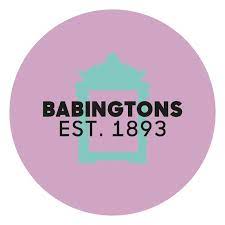 A purple circle with a teal coloured tea caddie and Babington's Est. 1893 written across the middle