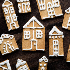 Iced gingerbread houses on a wooden backdrop.